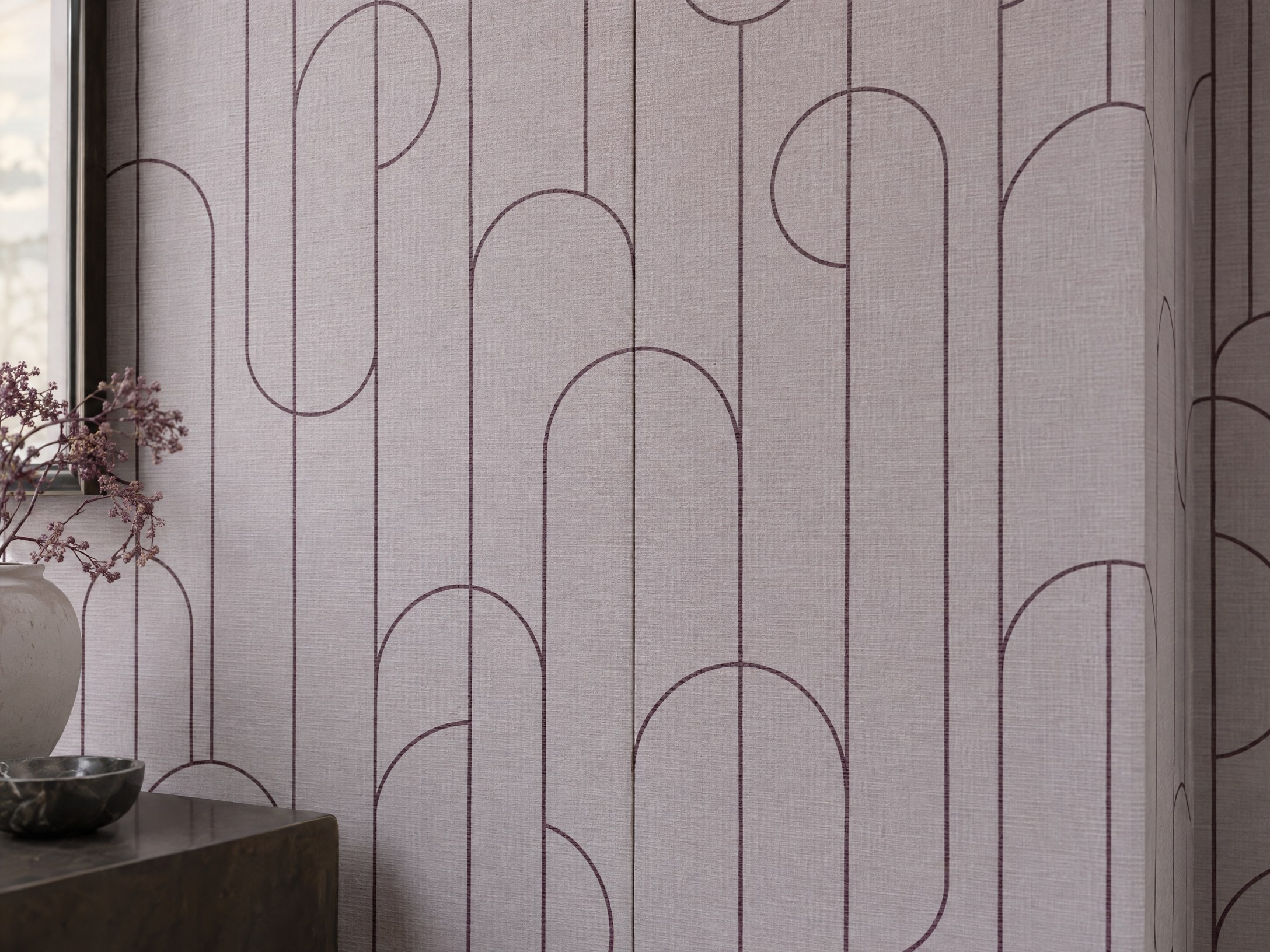 Close view of lilac textured wallpaper with precise plum lines aligned across a neat vertical seam